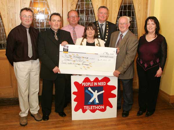 John OShaughnessy, chairman of the Mayo People in Need Committee, presents a cheque for 27,000 to Carmel Monaghan, Irish Wheelchair Association, at the distribution of 163,100 Euros collected in the "Telethon 2004 - People in Need" fundraising in the Welcome Inn Hotel Castlebar, included in photo from left Michael Larkin, John OShaughnessy, Michael Rooney, Carmel Monaghan, Pat Murray, President, Castlebar Chamber of Commerce and Tom Kenny and Helen Kenny. Photo Michael Donnelly