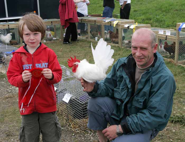 John Kenneth Dowling, Crossmolina holding his red rosette for his Bantan Cock, at the 88th Claremorris Agricultural Show, pictured with his dad John Dowling. Photo:  Michael Donnelly