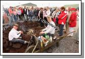 A crowd wait while eggs are boiled in a paperbay and sausages cook on the open turf fire at Claremorris Agricultural Show. Photo: Michael Donnelly.