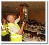 TJ Kelly  of Midfield Development Association displays a Clock (one of the many items) at the 24 Hour Auction in Julians of Midfield Swinford in an attempt to break a record in the Guinness book of Records. 