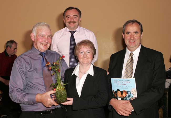 Paddy Walsh, Kilmaine makes a presentation to Josephine Taylor and John Taylor, Hon. President of the Irish Vintage Society at the Threshing Social in the Dalton Inn Hotel Claremorris; At back is Ger Delaney, MC for the night.  Photo: Michael Donnelly.