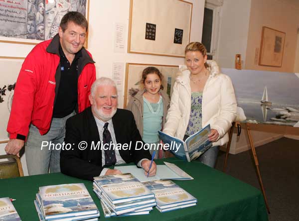 Northabout skipper Jarlath Cunnane pictured as he signs his book Northabout (sailing the North East and North West Passages) in the Linenhall Arts Centre Castlebar, included in photo are Rory Casey who also sailed on Northabout and Kate and Eavan Mongey Castlebar. In background is a photo from the the expedition. Photo:  Michael Donnelly