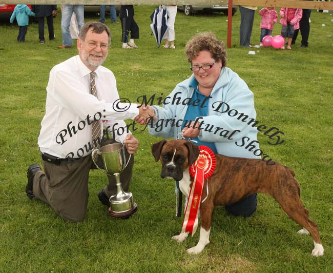 Patricia Coniry, Killimor, Ballinasloe is presented with the "Thomas Lyons Memorial Cup" (Champion Dog of Show Cup) at Roundfort Agricultural Show for her Champion Boxer by Dr Gerard Fleming Galway. Photo:  Michael Donnelly