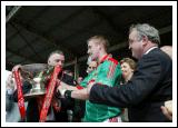 Lauri Quinn, President connacht Council presents  the Nestor Cup to Mayo captain David Heaney  in the Bank of Ireland Connacht Senior Football Championship in McHale Park Castlebar, watched by (partly hidden), Dr Martin McAleese and Uachtaran na hireann, Mary McAleese and Dr Mickey Loftus former President of the GAA