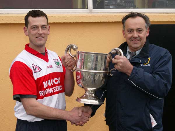Paddy Naughton, Chairman Mayo GAA County Bard presents the Pete McDonnell Memorial Cup to Aughamore  captain Liam Walsh after they defeated Ballina Stephenites B in the Breaffy House and Spa  County Junior  Football Final in McHale Park Castlebar. Photo: Michael Donnelly
