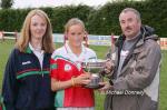 Jimmy McGing presents the Aisling McGing Memorial Cup to his daughter Sharon McGing, captain of the Carnacon team after they defeated Castlebar Mitchels in the final of the Aisling McGing Memorial Cup Tournament in Clogher Included in photo is Beatrice Casey, chairperson Carnacon Ladies GAA Club. Photo Michael Donnelly