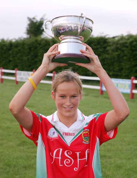 Sharon McGing, captain of the Carnacon team raises the Aisling McGing Memorial Cup after they defeated Castlebar Mitchels in the final of the Aisling McGing Memorial Cup Tournament in Clogher. Photo Michael Donnelly