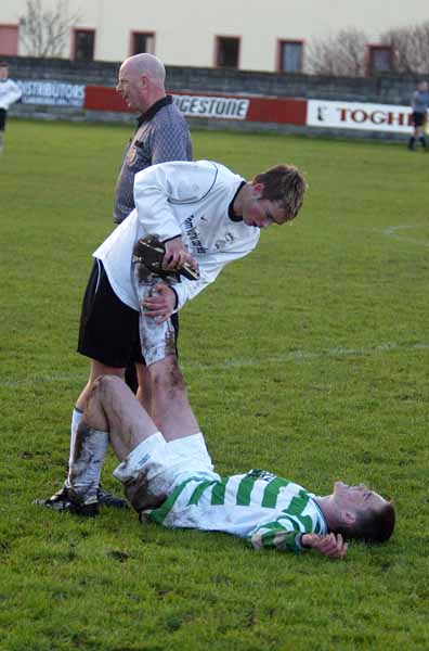 Alan Brooks Tramore shows sportsmanship  as he  relieves cramp  for Niall O'Hara Castlebar Celtic inthe SFAI U-17 at Celtic Park Castlebar. Photo Michael Donnelly