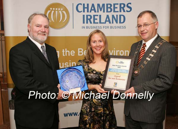 Martin Lawless of Mayo Crystal (sponsors) presents the Customer Service Award Leisure and Tourism  Sector to Catherina O'Grady Powers of Asgard Bar and Restaurant Westport, on right Owen Hughes, President Westport Chamber of Commerce. Photo:  Michael Donnelly
